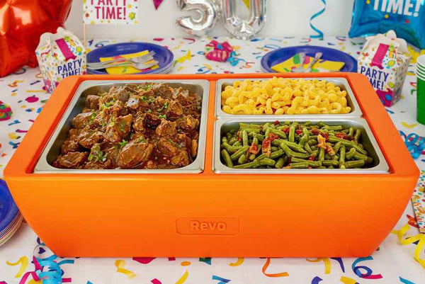 Orange two-compartment chafer holding seasoned meat and green vegetable sides