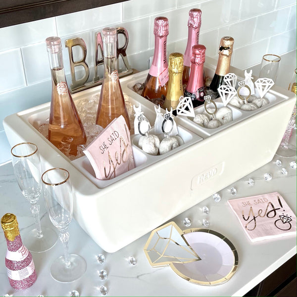 White party cooler bin holding champagne bottles, stemware, and ice