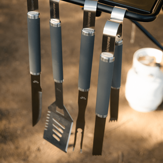 Grilling tool set with gray handles and stainless heads on stand