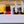 Load image into Gallery viewer, White party cooler bin with ice, cups of drink, fruit, and champagne bottles
