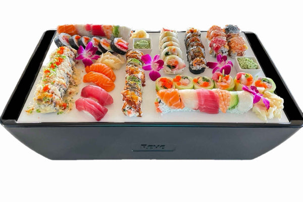 Black chill board tray with assorted sushi, seafood pieces, and floral garnishes