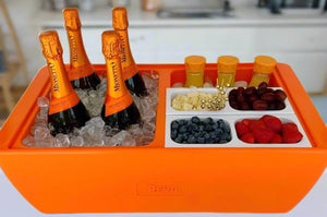 Orange party cooler with bottle holders, ice, and fruit tray for drinks