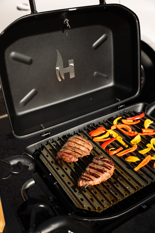 steaks and bell peppers on grill grate
