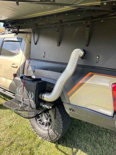 Black mesh tire table with aluminum frame mounted at the back of a pickup