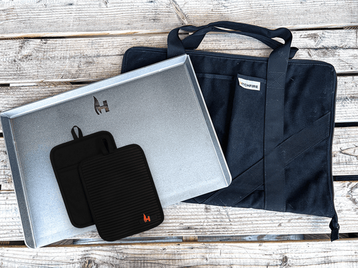 Cast iron griddle kit with metal tray, black gloves, and dark carry bag