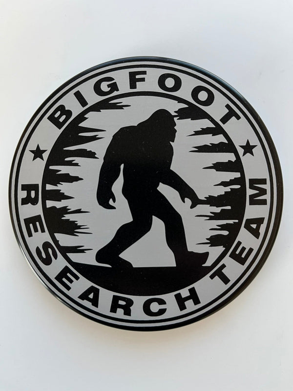 Round hitch cover with Bigfoot silhouette, stars, and ring of bold logo text