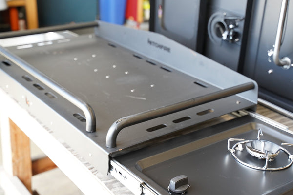 Cook station with HitchFire logo, side burner and dark gray grill grate shelf