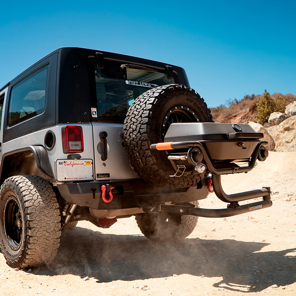 Jeep Wrangler on a dirt road with a clear blue sky