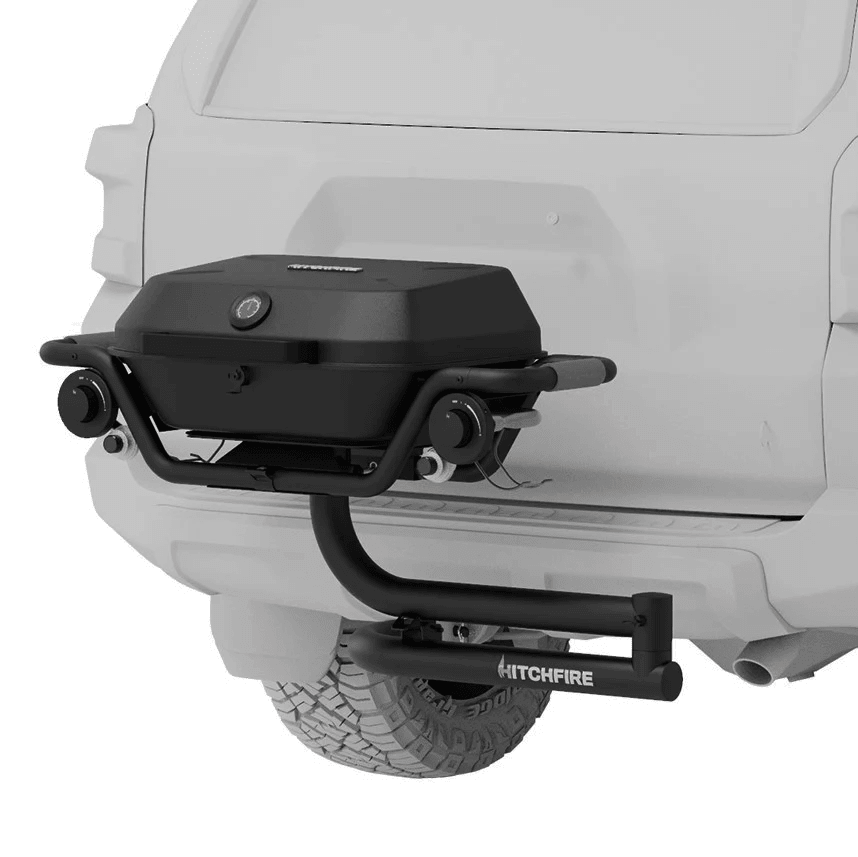 Hitch mounted propane grill with closed lid, side handle, and control knobs in dark finish.