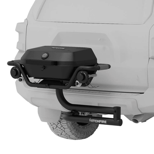 Hitch mounted propane grill with closed lid, side handle, and control knobs in dark finish.