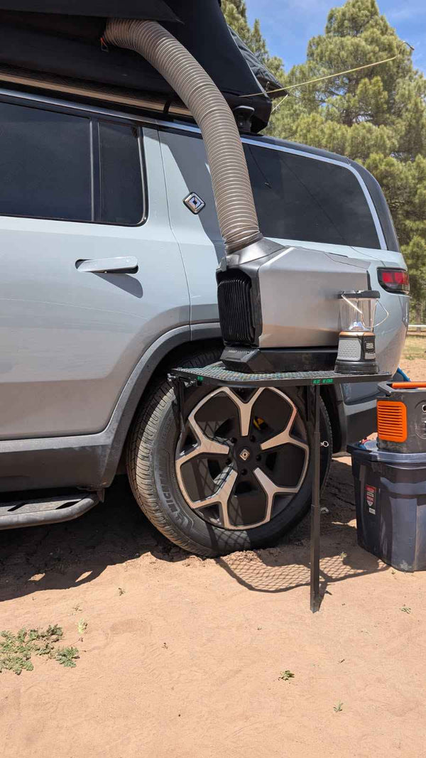 Camping tire table platform with black mesh and fold-out stand on a pickup