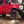 Load image into Gallery viewer, Large black aluminum camping table with wire mesh top, set on ground near a truck

