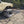 Load image into Gallery viewer, Large black aluminum camping table with wire mesh top on ground near a parked vehicle
