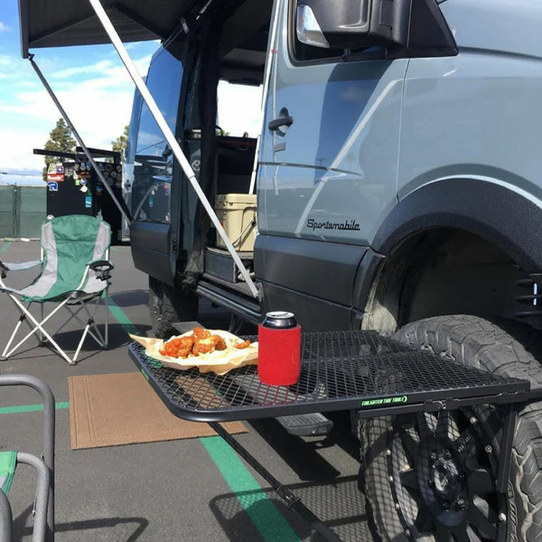 Black steel camping table with rectangular mesh surface and folding support frame