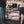 Load image into Gallery viewer, Black steel camping table with rectangular wire-mesh surface for cookware
