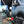 Load image into Gallery viewer, Black steel camping table with rectangular mesh top and folding legs near a van
