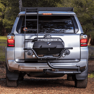 Hitch mounted propane grill at rear of vehicle, closed lid and front burner controls visible.