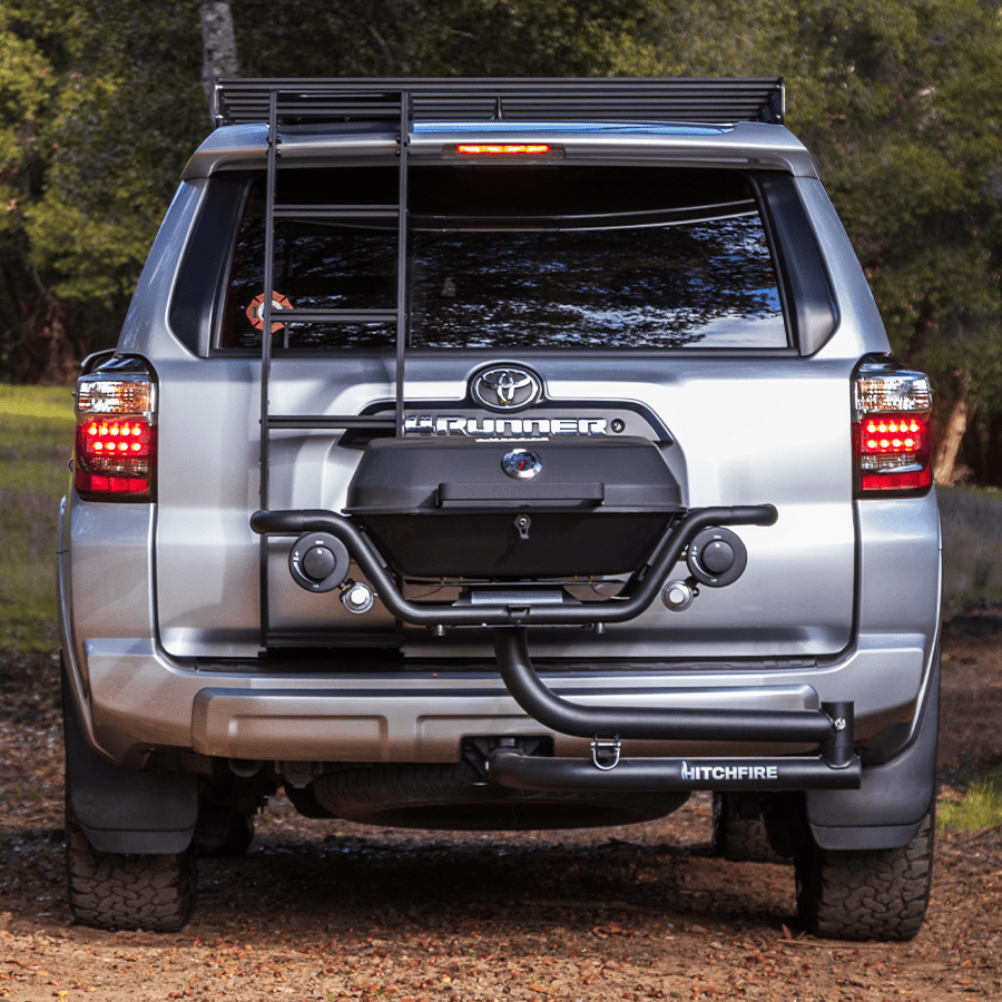 Hitch mounted propane grill at rear of vehicle, closed lid and front burner controls visible.