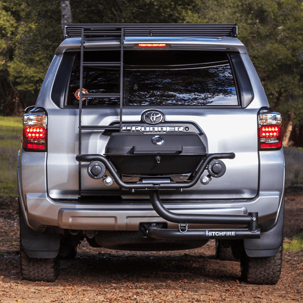 Hitch mounted propane grill at rear of vehicle, closed lid and front burner controls visible.