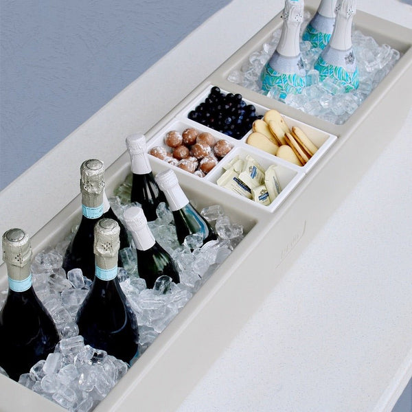 Greige mist party barge cooler with divided compartments, bottles, and ice.