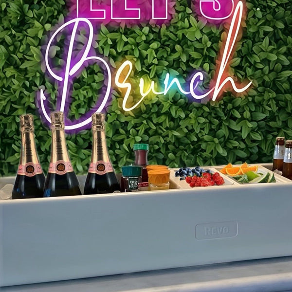 Greige mist party barge cooler with champagne bottles and fruit tray.