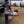 Load image into Gallery viewer, Black camping table with wire mesh surface and small side platform, outdoors next to a vehicle.
