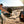 Load image into Gallery viewer, Hitch mounted propane grill with open lid and cooking grate, dark body with front controls.
