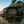 Load image into Gallery viewer, Hitch mounted propane grill with open lid and cooking grates, dark body with control knobs.
