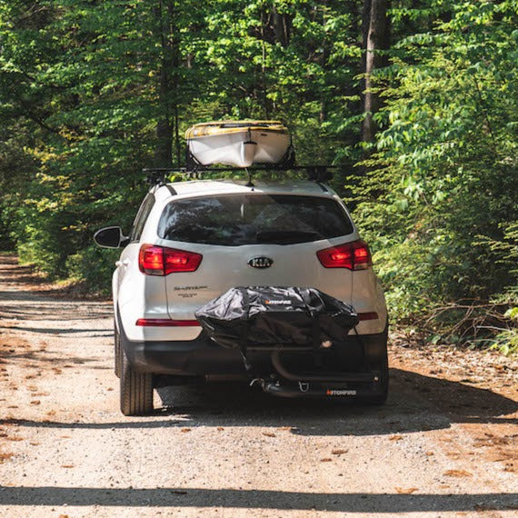 Kia with canoe driving away with grill cover