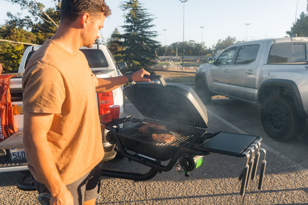 Grill open with steaks at tailgate