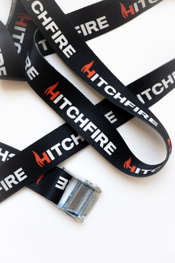 Cam straps with HITCHFIRE printed webbing and metal buckles, laid out