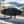 Load image into Gallery viewer, Black grill cover with HitchFire logo on grill, held by straps and legs
