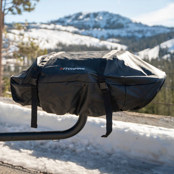 Black grill cover with HitchFire logo on grill, held by straps and legs