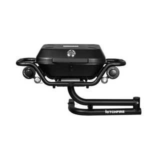 Black propane grill with lid closed, two front control knobs and HITCHFIRE hitch frame