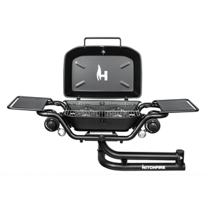 Hitch mounted propane grill with open lid, wire cooking grate, and two side shelves in black.