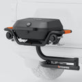 Hitch-mounted propane grill side view with orange accents and round burner knobs
